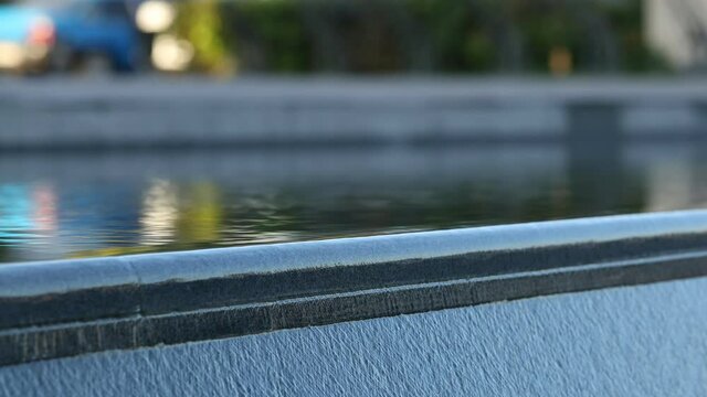 Water spilling over the edge of a water sculpture. Selective focus.
