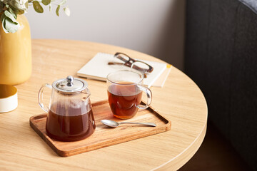Fresh tea near notepads and glasses
