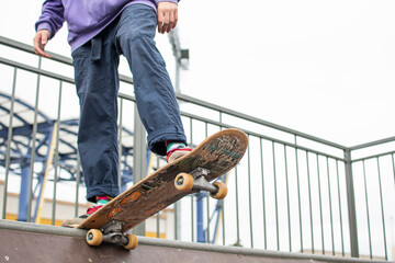 a young guy is engaged in jumping on a skateboard. an old skateboard. active sport among young people. injury-prone sport