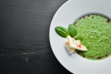 Spinach puree soup in a plate. Top view. Free copy space.