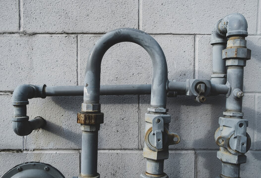 Detail of natural gas meter and piping on side of building wall