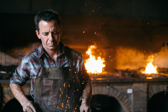 Blacksmith working near hearth
