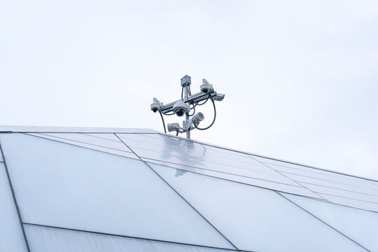 Surveillance camera and security system on modern building rooftop