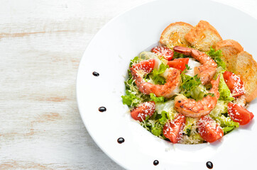 Vegetable salad with shrimp and cherry tomatoes. Caesar salad with prawns. Top view. Free space for your text.