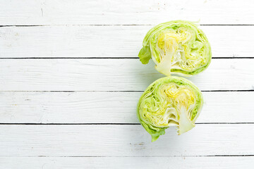 Lettuce on a white wooden background. Green healthy food. Iceberg lettuce. Top view. Free copy...