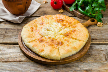 khachapuri with cheese on old wooden table, imeretian, georgian kitchen.