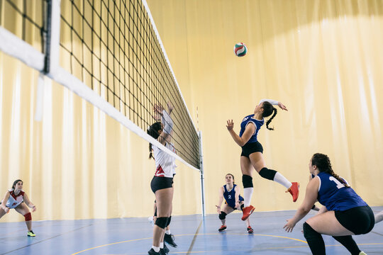 Focused female volleyball player blocking served ball while tournament in Madrid, Spain.