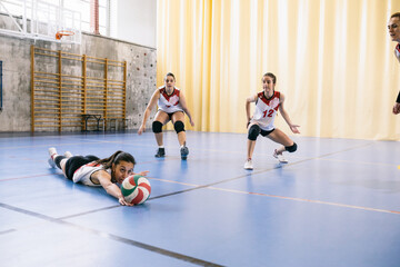 Competitive female volleyball team failing blocking ball while tournament in Madrid, Spain.