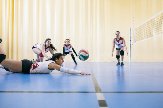 Competitive female volleyball team failing blocking ball while tournament in Madrid, Spain.