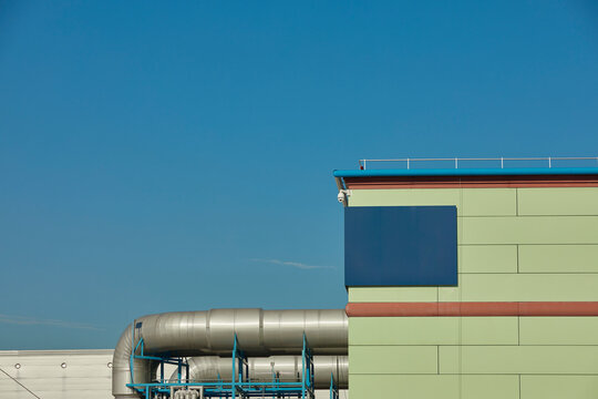 Industrial building with pipe against blue sky