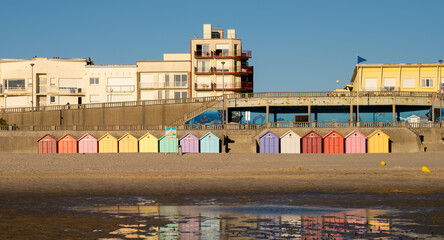 Row of vintage beach huts reflected on a beach in France