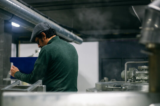 Bearded brewer making notes in journal