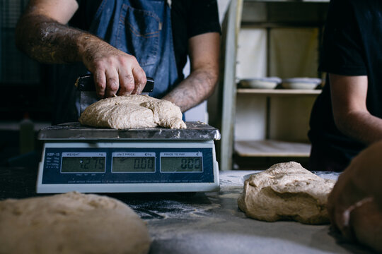 Baker weighing dough on scales