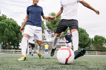 Crop sportive players in motion of running on green grass kickin