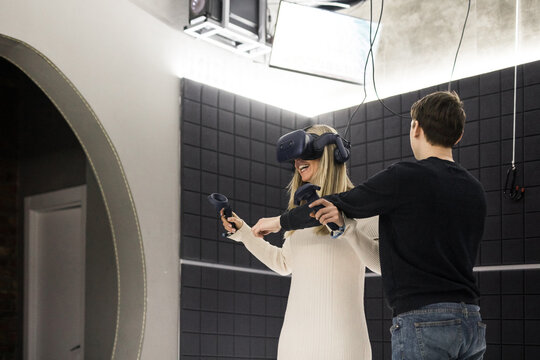 Man securing a woman experiencing VR from falling