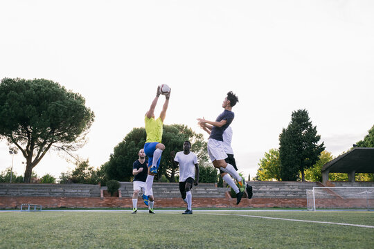 Fast and strong goalkeeper jumping high to catch ball defending
