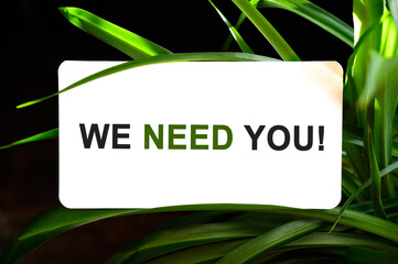 WE NEED YOU text on white surrounded by green leaves