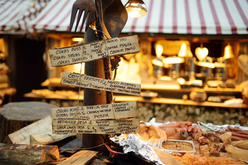 Menu written in different languages on wooden plates on the most authentic Christmas market in Riga offering dozens of crafts and food stalls.