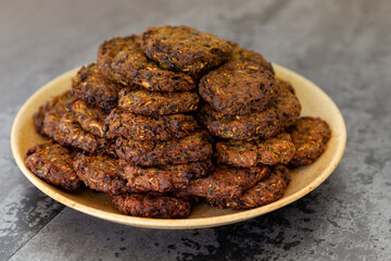 Heap of homemade baked courgette cakes on plate. Vegetarian cousine snacks.