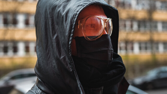 Man wearing black medical mask and goggles outside