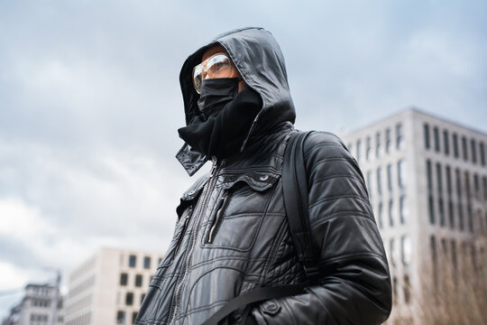 Man wearing black medical mask and goggles outside