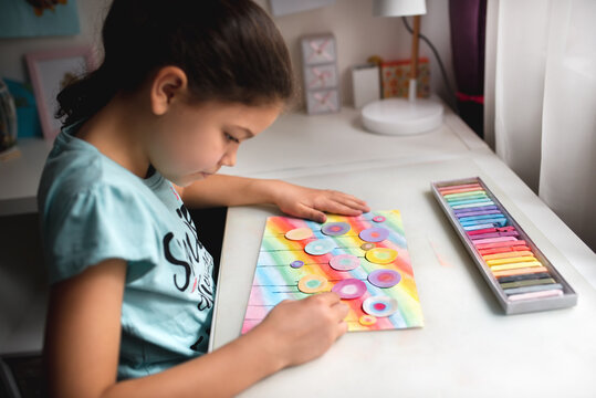 Child drawing a field of flowers with chalk pastel