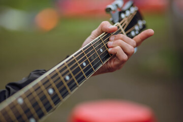 Close up of guitarist hand playing acoustic guitar.