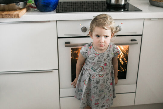 Grumpy little girl baking cookies