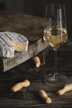 Still Life Of Fresh Cheese And Breadsticks With Prosecco On Wooden Cutting Board