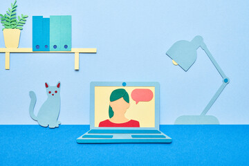 Laptop with female speaker near cat and lamp