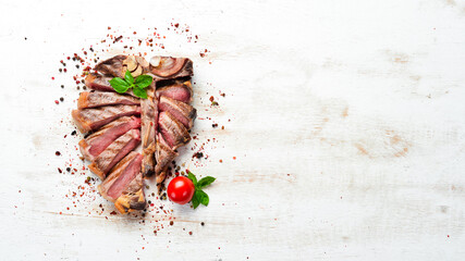 Sliced roast veal steak with rosemary and spices. Top view. Free space for your text.