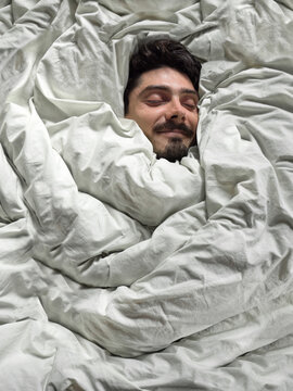 Young man wrapped in a blanket
