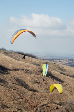 Three men paragliding