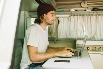 Young Man working remote from his Van