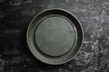 Metal kitchen form for baking food. On a black background. Top view. Free copy space.