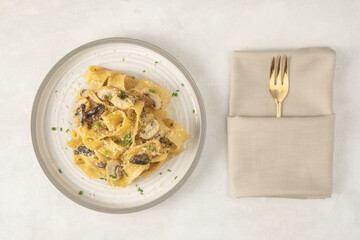 Homemade Italian fettuccine pasta with mushrooms and parmesan (Fettuccine al Funghi Porcini). Traditional Italian cuisine. Served  on white background. Top view.