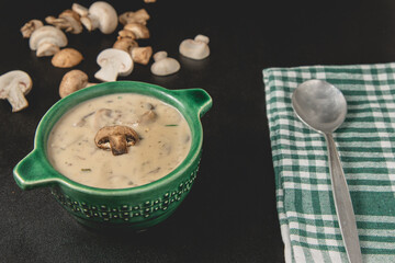 Homemade mushroom cream soup. Served on a dark background. Close-up view.
