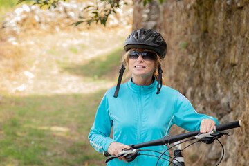 Fototapeta na wymiar woman with bicycle and helmet outdoors