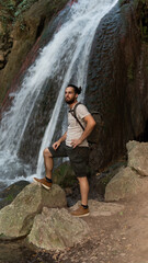 A Man Standing In Front Of A Huge Water Fall