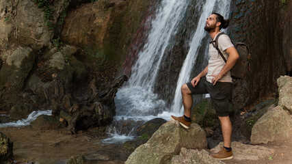 A Man Standing In Front Of A Huge Water Fall