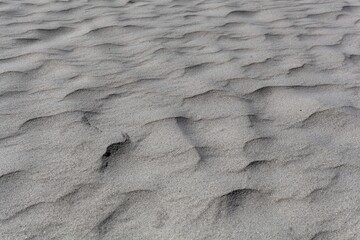 Textures in grey coarse grained sand.