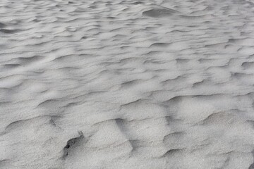 Textures in grey coarse grained sand.