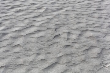 Textures in grey coarse grained sand.