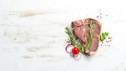 Raw T-bone steak on white wooden table. Top view. Free space for your text.