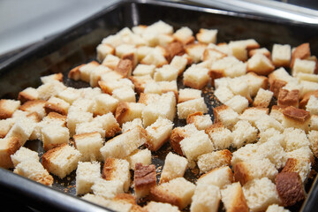 Square toasted pieces of homemade delicious rusk, hardtack, Dryasdust, zwieback on a baking sheet.