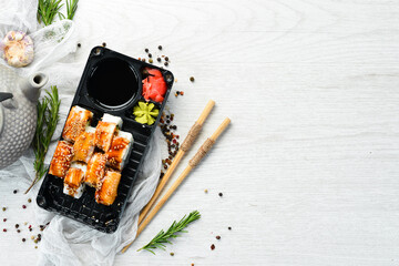 Delicious Japanese sushi rolls with eel and Philadelphia cheese. Delivery of food in plastic boxes. Top view.