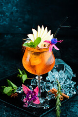 Cocktail in a glass - Aperol spritz. on a black stone background. Menu bar. Alcohol.