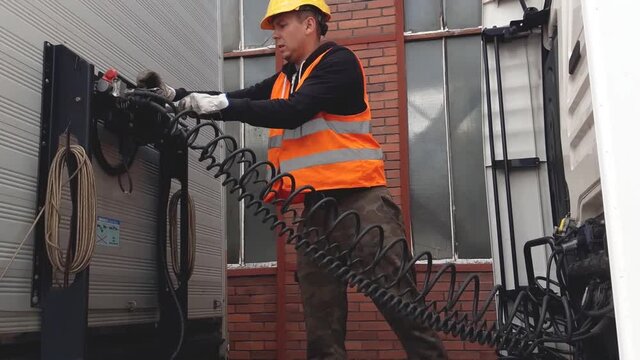 Truck driver disconnect hoses and wires from semi-trailer