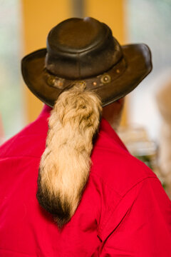 View of a man in a hat with an animal tail.