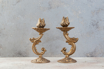 Antique candlesticks on concrete background.